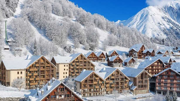 A snow-covered mountain resort with wooden lodges and a ski lift. - 2-Person Studio near Ski Lifts (VAUJANY (ISERE))