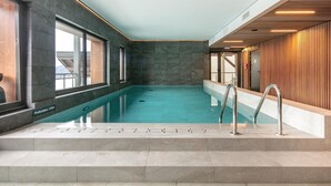 An indoor swimming pool with a clear view of the surrounding walls, a wooden panel design on one side, and a tiled floor. - 2-Person Studio near Ski Lifts (VAUJANY (ISERE))