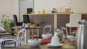 A modern cafe interior with a wooden counter, clear chairs, and hanging pendant lights. - Studio in the Vezere Valley (LES  EYZIES  DE  TAYAC)