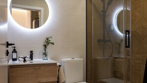 Ein modernes Badezimmer mit Toilette, Waschbecken und Duschkabine.