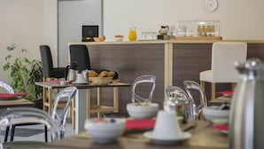 A modern cafe interior with a wooden counter, clear chairs, and hanging pendant lights. - Stay Near Prehistoric Sites (LES  EYZIES  DE  TAYAC)