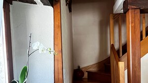 Uma escada de madeira com um vaso de planta no patamar.