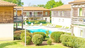 Ein Poolbereich mit Liegestühlen, einer Pergola und einem kleinen Garten.