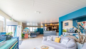 A modern hotel lobby with a reception desk, seating area, and a view of the reception. - Oceanfront Duplex Retreat in Biscarrosse (Biscarrosse)