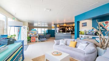 Un hall d’hôtel moderne comprenant un comptoir d’accueil, un espace salon et une vue sur la réception.