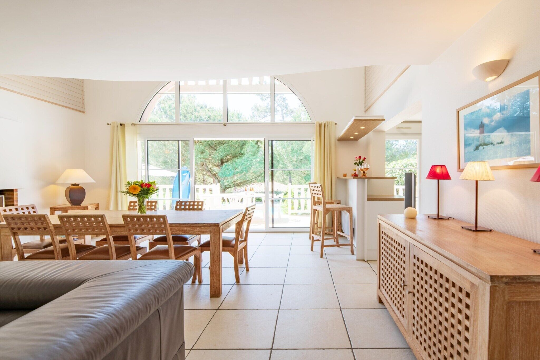 Une pièce spacieuse comprenant un coin repas, un canapé et un espace cuisine avec un comptoir et des chaises.