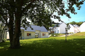 A residential area with houses, a tree, and a grassy lawn. - Spacious Duplex Cabin Cottage for 6 (Audierne)
