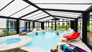 A glass-enclosed swimming pool with lounge chairs and a hot tub. - Spacious Coastal Duplex Cottage for 8 (Audierne)