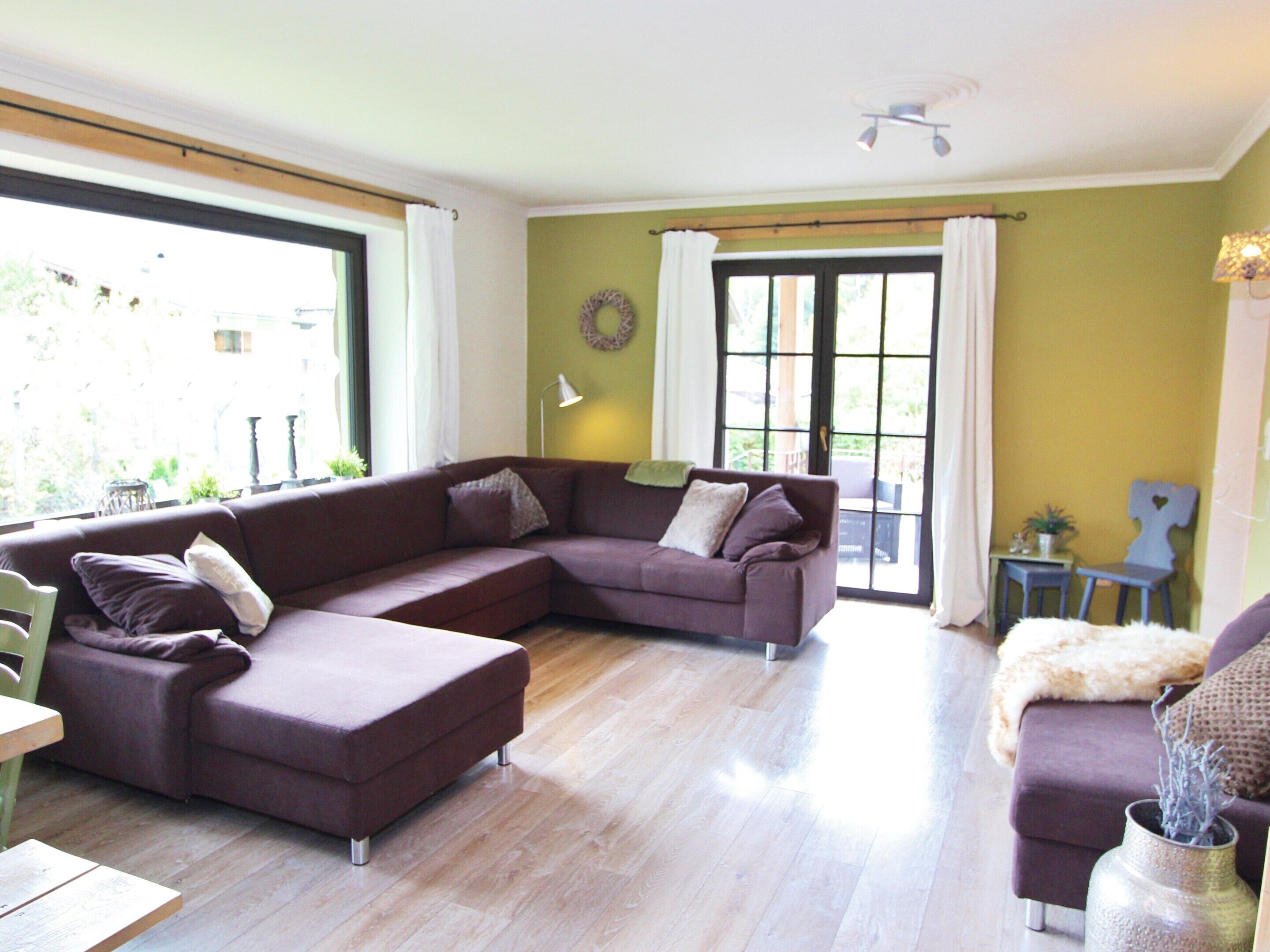 A living room with a sectional sofa, a small table, and a chair.