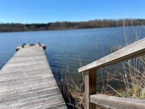 Un muelle de madera que se adentra en una masa de agua bajo un cielo despejado.