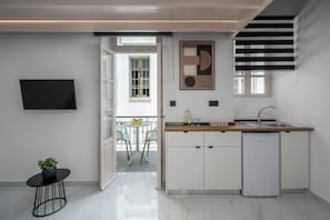 Eine moderne Küche mit integriertem Geschirrspüler, einem Essbereich mit Tisch und Stühlen sowie einem an der Wand montierten Fernseher.