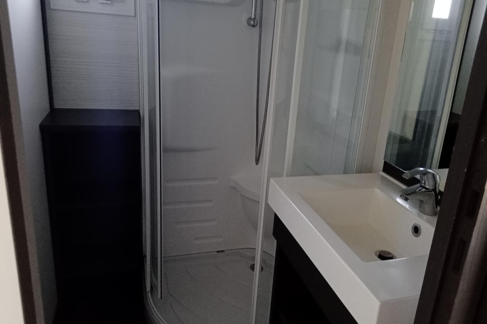 A bathroom with a shower, a sink, and a mirror.