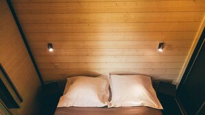 A small, cozy room with a wooden ceiling, a bed with white linens, and two wall-mounted lights. - Spacious Cottage for 6 in Marminiac (Marminiac)
