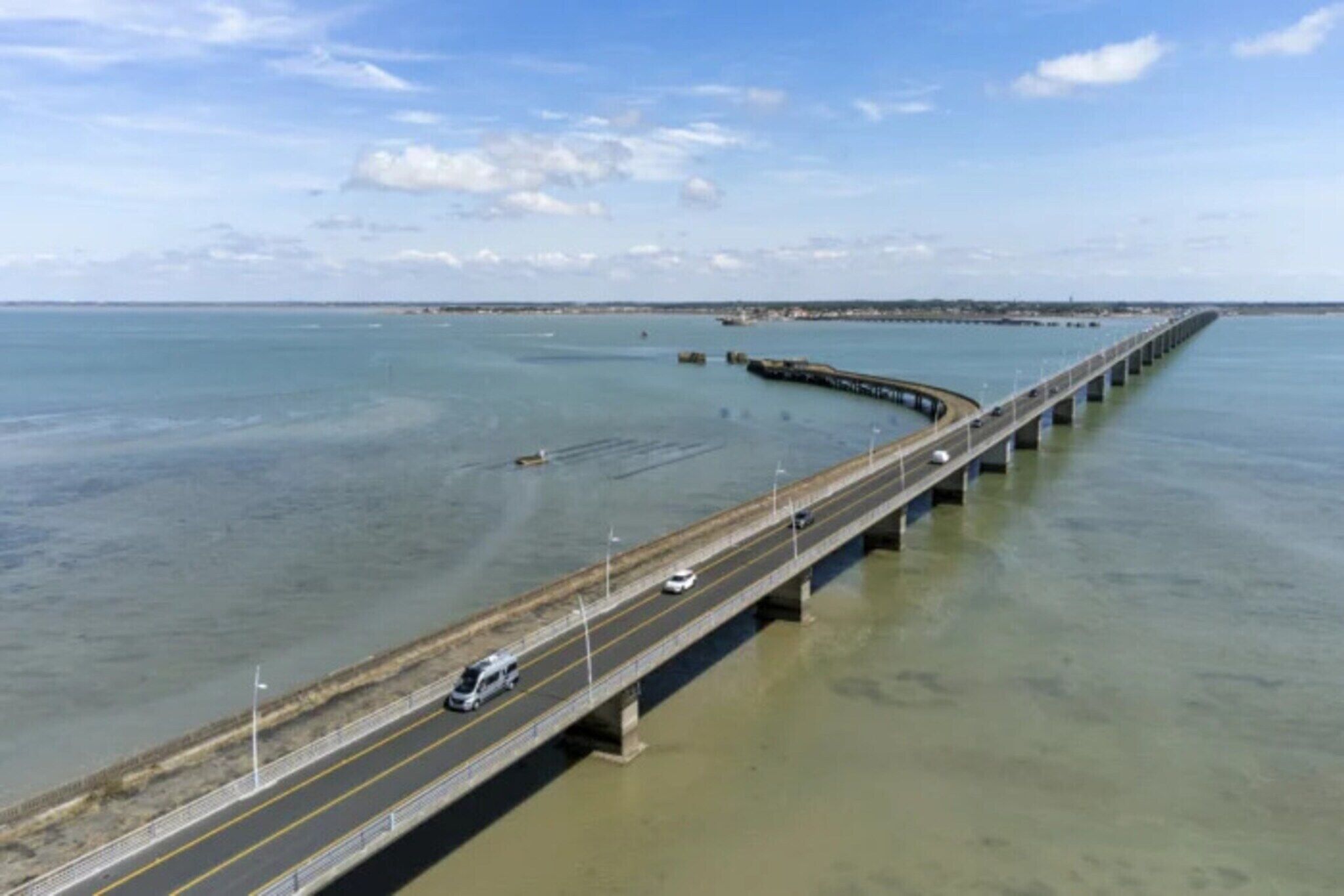 Un long pont enjambant une étendue d’eau, comportant plusieurs voies de circulation pour les véhicules.