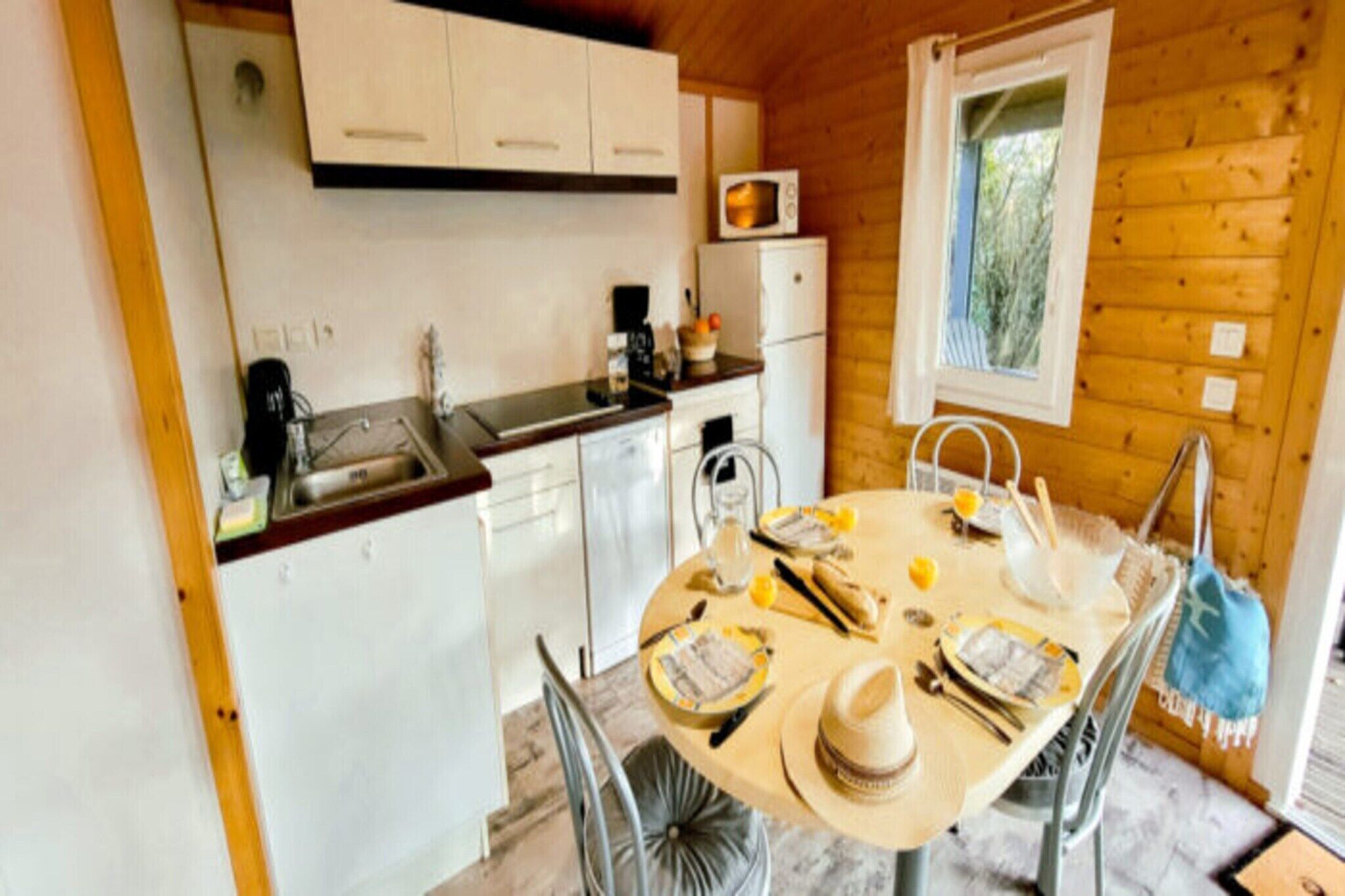 Une cuisine de taille réduite, avec des meubles blancs, un four à micro-ondes et un évier.