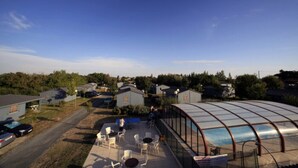 A residential area with houses, a swimming pool, and a covered outdoor seating area. - Coastal Family Cottage for Six (Saint-Denis-d'Oléron)