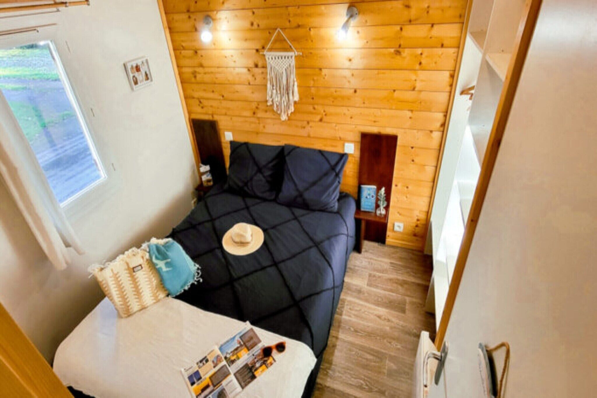 A compact bedroom with a bed, a small table, and a window.