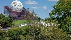 A modern building with a large spherical structure, a sloped roof with solar panels, and a green lawn. - Spa Retreat in La Roche-Posay (La Roche-Posay)