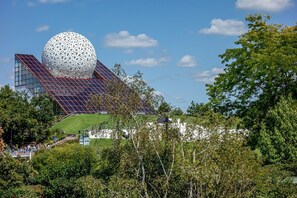 A modern building with a large spherical structure, a sloped roof with solar panels, and a green lawn. - Spa Retreat in La Roche-Posay (La Roche-Posay)
