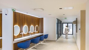 A modern reception area with a wooden panel wall, a reception desk, and blue chairs. - Spa Retreat in La Roche-Posay (La Roche-Posay)