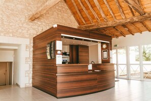 Una recepción con detalles de madera, un reloj y un letrero que indica la disponibilidad de WiFi.