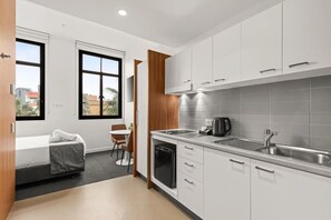 A modern kitchen with white cabinets, a stainless steel sink, and a built-in dishwasher. - Comfort Inn Geelong (Geelong)