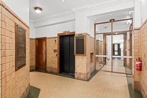 A hallway with a fire extinguisher, a door with a number plate, and a wall-mounted plaque. - Comfort Inn Geelong (Geelong)