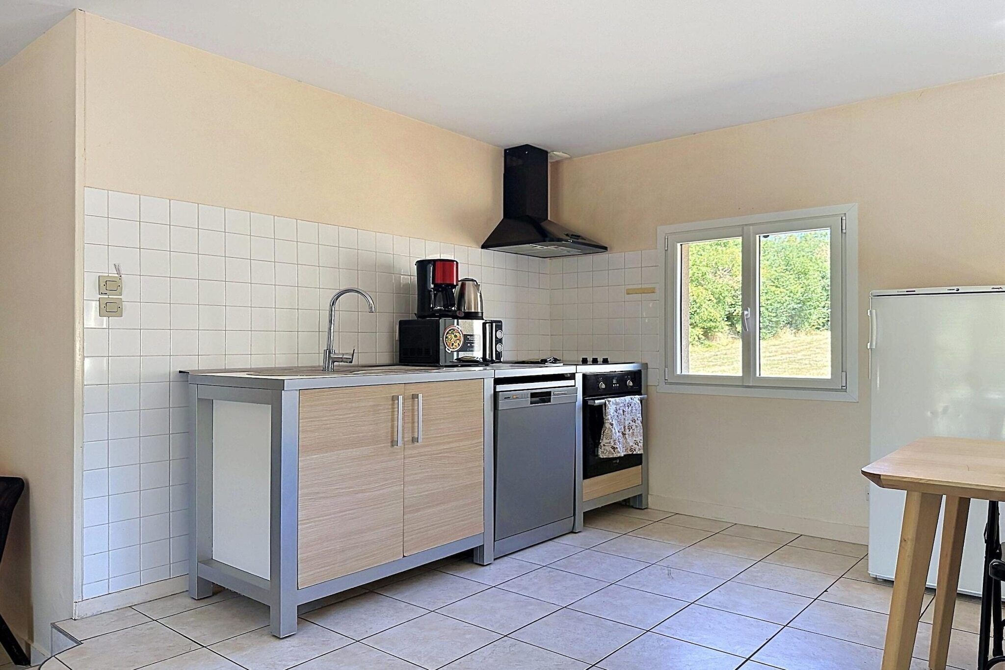 A compact kitchen with a sink, stove, and a window.
