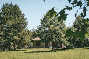 A house with a tiled roof, surrounded by trees and grass.