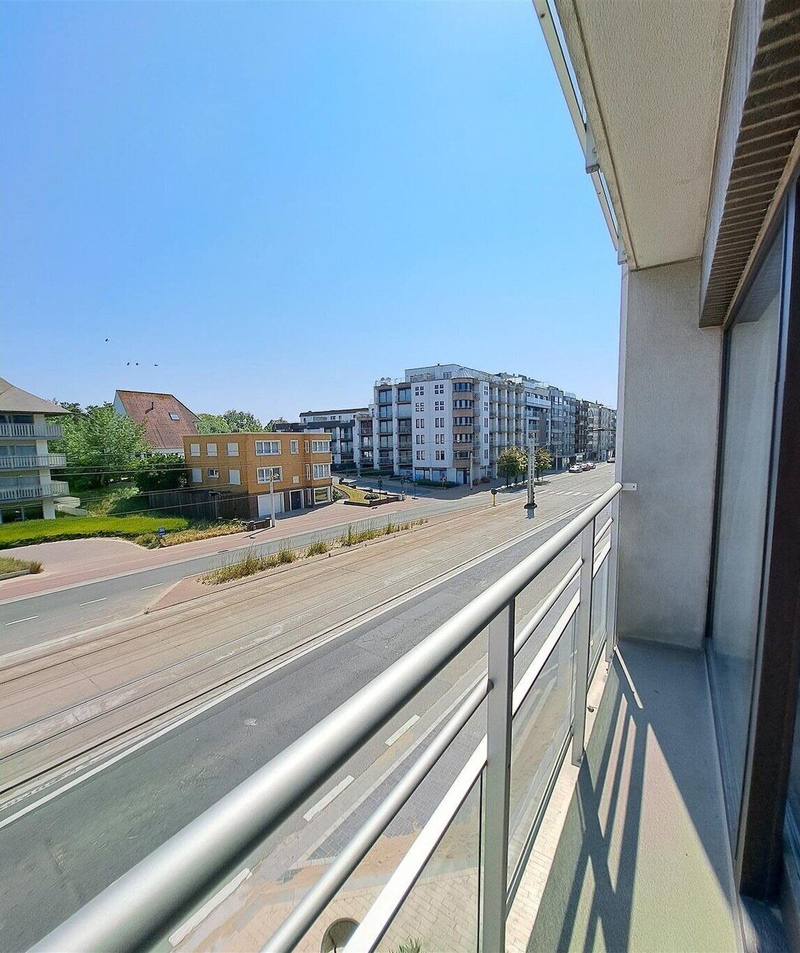 A balcony overlooking a multi-story residential building with a clear sky.