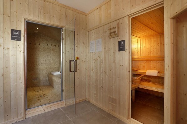 Un sauna en bois avec une porte en verre donnant accès à un espace douche.