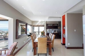 Ein modernes Interieur mit Essbereich, Küche und großen Fenstern mit Blick.