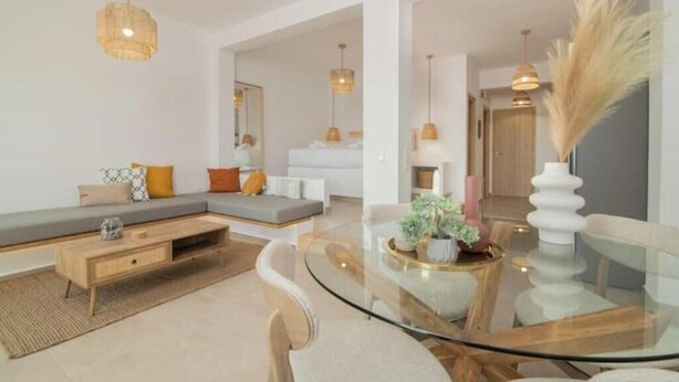 A modern living room with a glass coffee table, a sofa, and a dining area with a glass table and chairs. - Casa Tu Zante ❤️- center & sea view (for 6 guests) (Zakynthos)