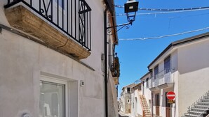 Une ruelle étroite pavée, bordée de bâtiments des deux côtés, une porte avec un numéro et un panneau indiquant l’interdiction d’accès.