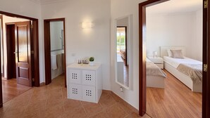Ein Hotelzimmer mit Bett, Nachttisch, Spiegel, einem kleinen Schrank und Blick ins Freie.