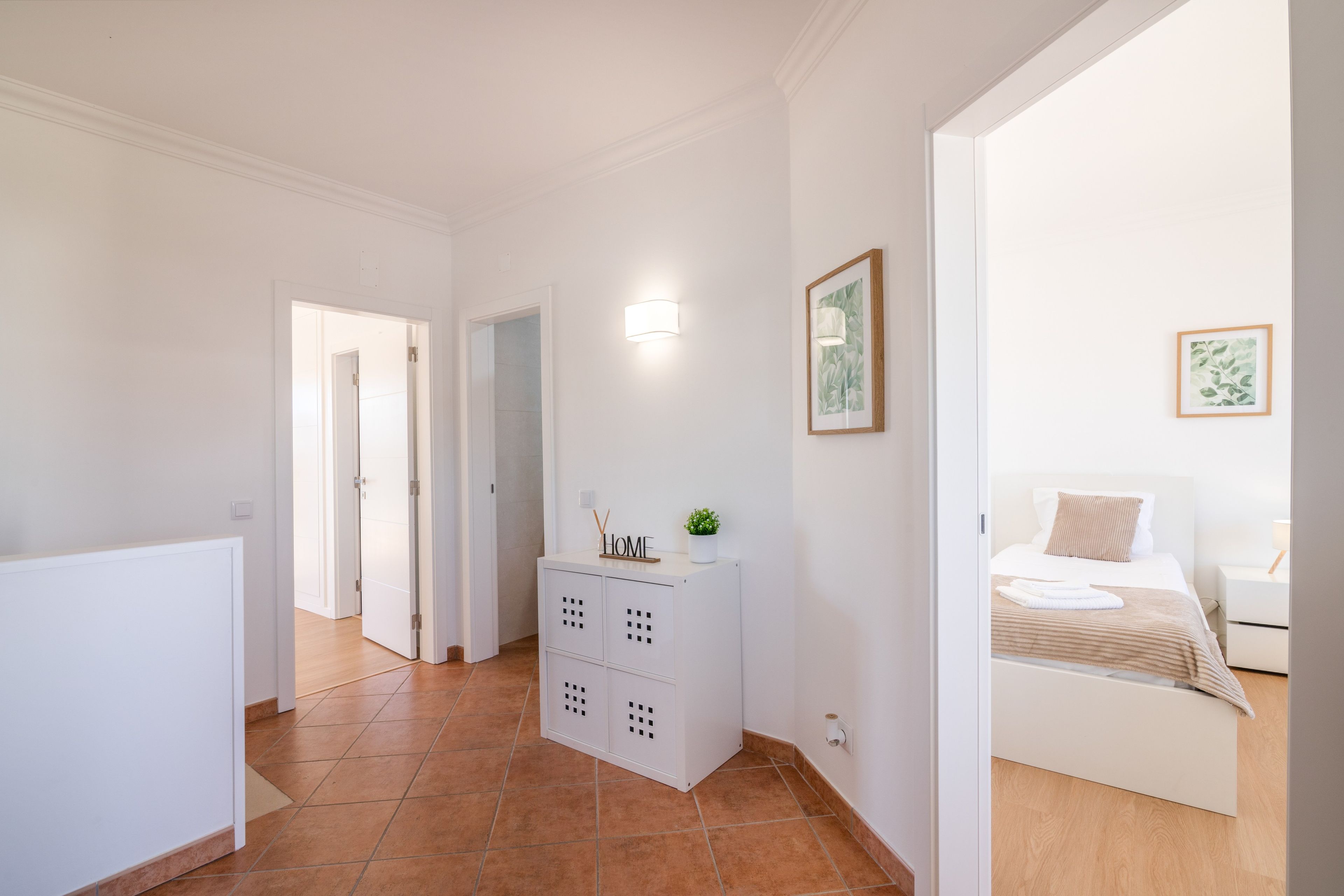 Ein Hotelzimmer mit Bett, Nachttisch und einer kleinen Topfpflanze.