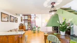 A spacious living area with a wooden dining table, a sofa, and a kitchen in the background. - Secret Loft in Trastevere - Moro (Rome)