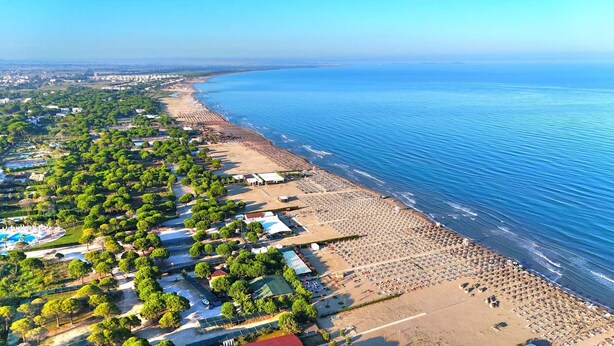 An aerial view of a coastal area with a beach, a pool, and a dense green park area. -  A beautiful cozy apartment very close to the beach and to all amenities. (Durrës County)