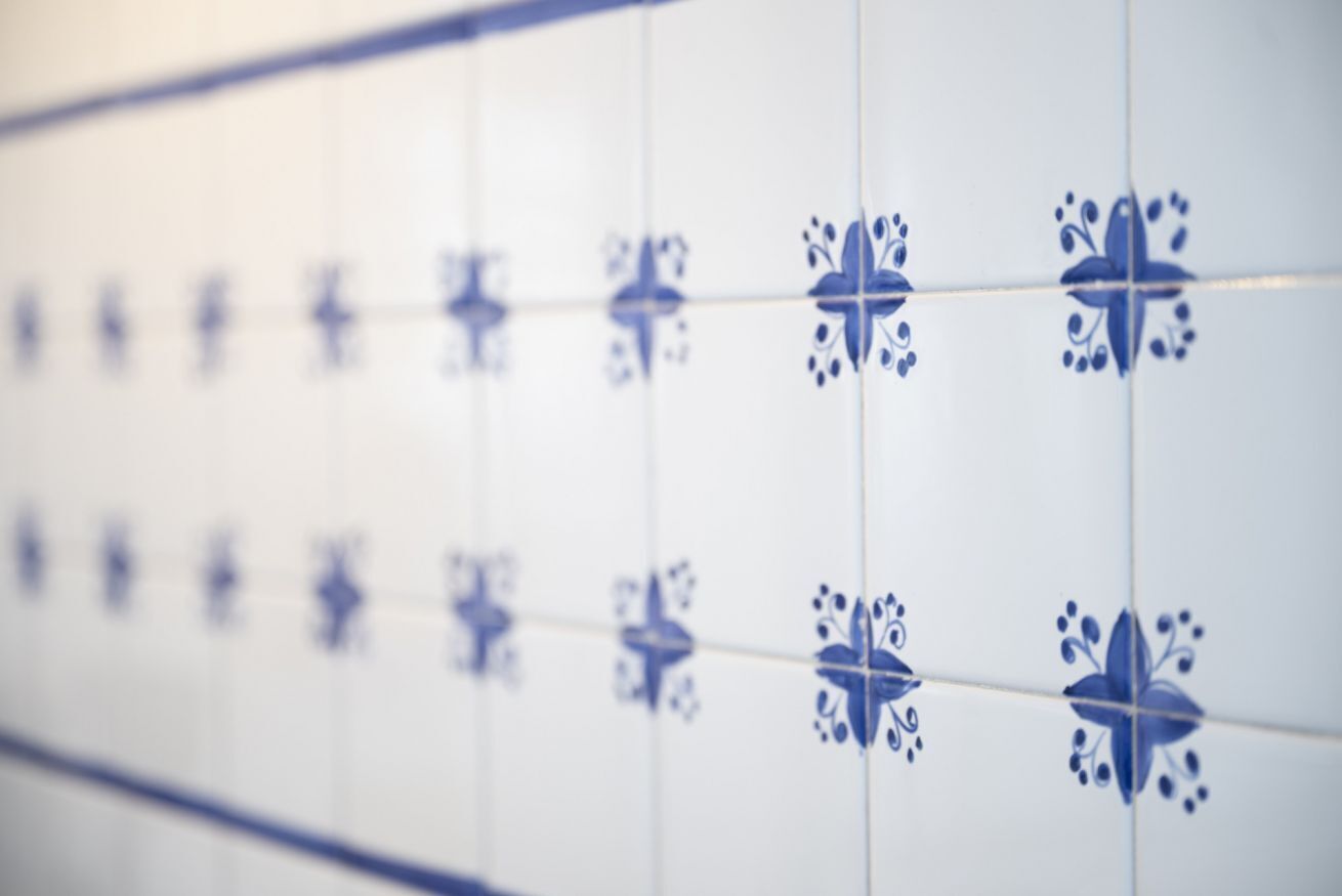 A close-up of a tiled wall with a repeating pattern.