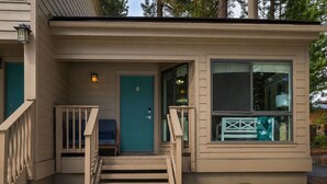 Ein kleines, eingeschossiges Gebäude mit einer Veranda, einer Tür mit der Nummer 8 und einem Fenster, durch das man das Innere sehen kann.