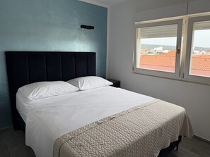 A bed with white linens, a dark headboard, and a beige quilted bedspread. - Cozy Stay for 2 in Sukosan (Sukosan)