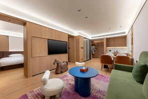 A modern hotel room with a bed, seating area, TV, and a small table. - La Quinta by Wyndham Lishui Yunhe (Lishui)