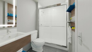 Un baño moderno con ducha, inodoro y lavamanos.