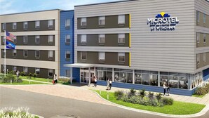 Edificio de Microtel Inn & Suites con diseño moderno, varios pisos y una zona de entrada cubierta.