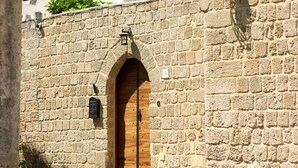 Un edificio de piedra con puerta de madera y acceso abovedado.
