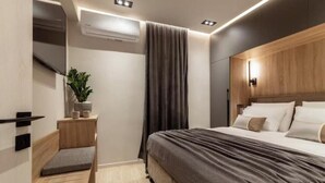 A modern bedroom with a bed, bedside table, and a small bench. - Chrison modern house (Zakynthos)