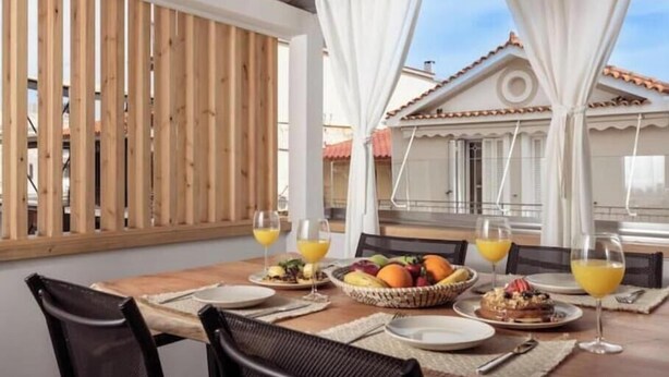 A dining table with chairs, a basket of fruit, and glasses of orange juice. - Chrison modern house (Zakynthos)