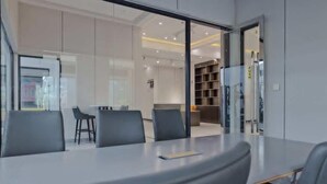Una sala de conferencias moderna con separador de vidrio, una pizarra y una estantería.