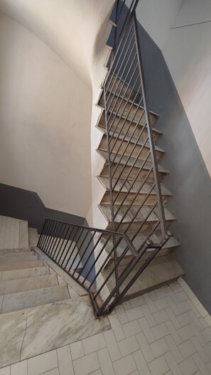 A staircase with metal railings and beige tiled steps. - Five Boutique Rooms (Naples)