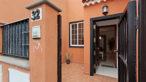 Un bâtiment portant le numéro « 32 », avec une fenêtre, une porte et un pot de fleurs.